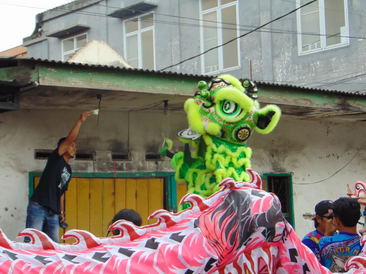 A man was trying to give money to the lion dancer. It was attraction on its own