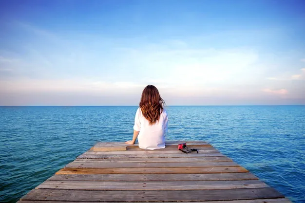 girl-sitting-alone-wooden-bridge-sea-frustrated-depression_335224-1019.webp