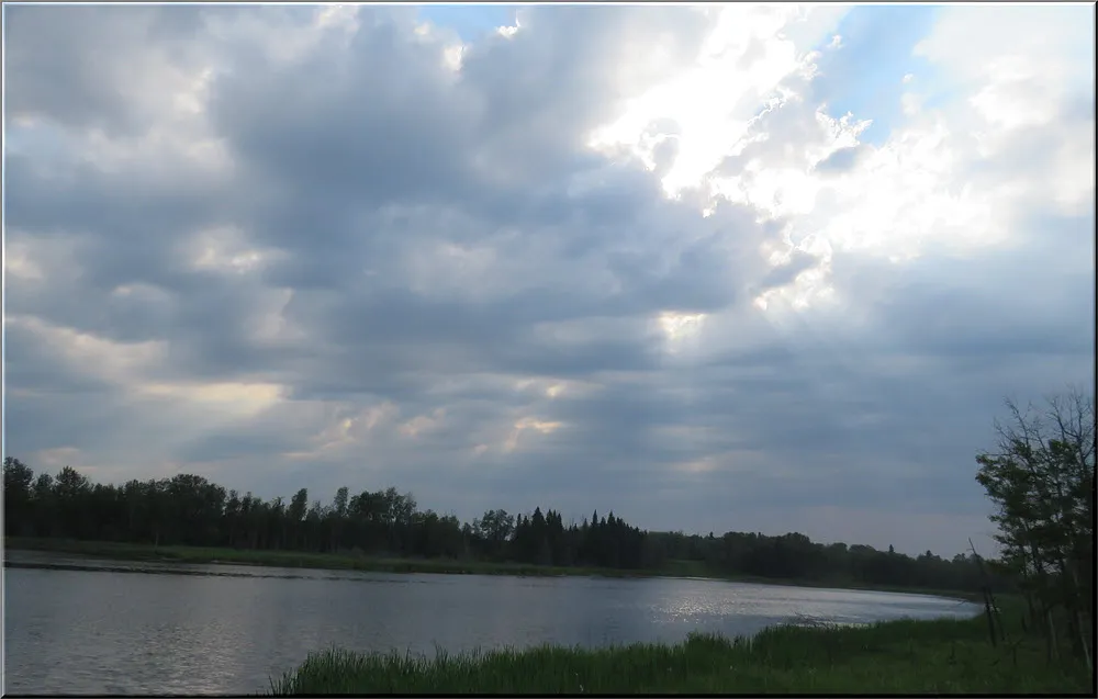 cloud throwing sunrays over pond.JPG