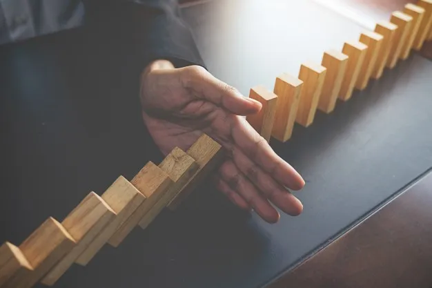 problem-solving-close-up-view-on-hand-of-business-woman-stopping-falling-blocks-on-table-for-concept-about-taking-responsibility_1418-55.jpg