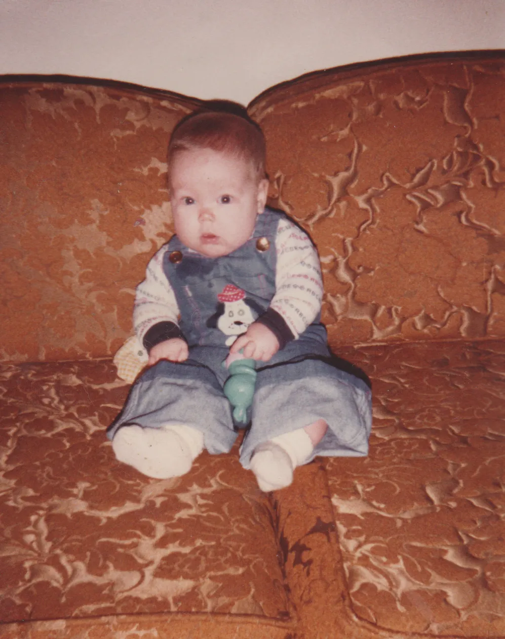 1981 maybe - Katie - Sitting on a couch.png