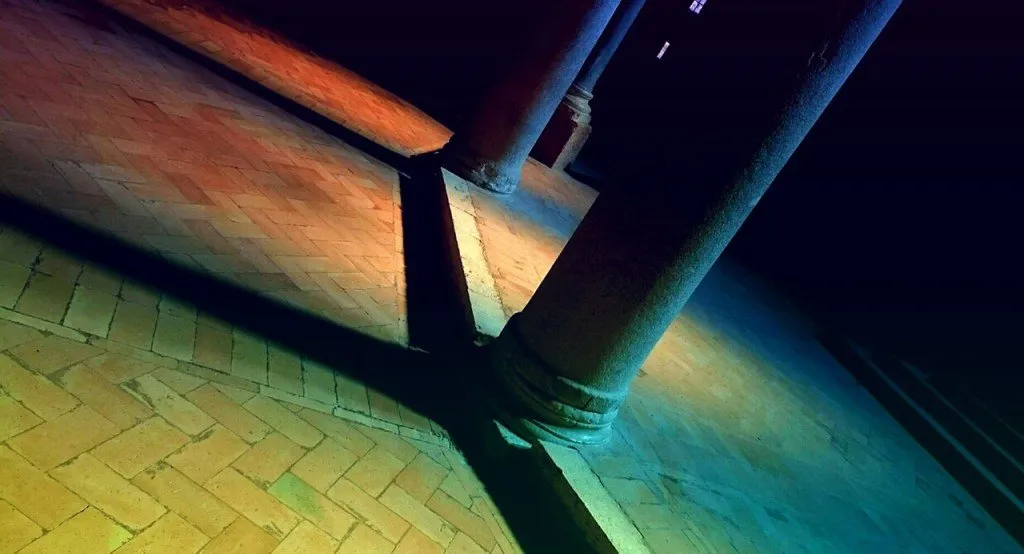 Pillars casting a shadow on multi-hued light.