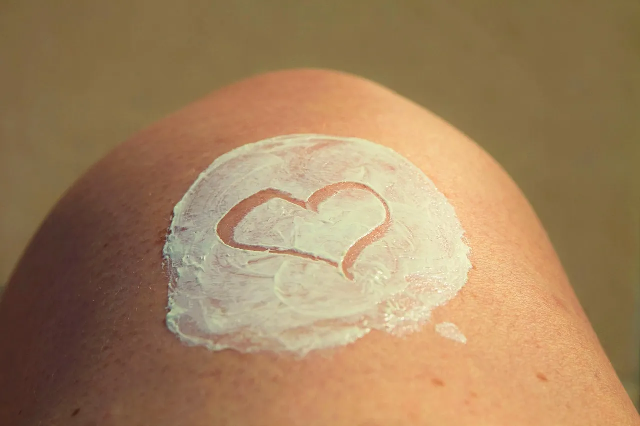 A heart drawn in sunscreen on a person's leg.