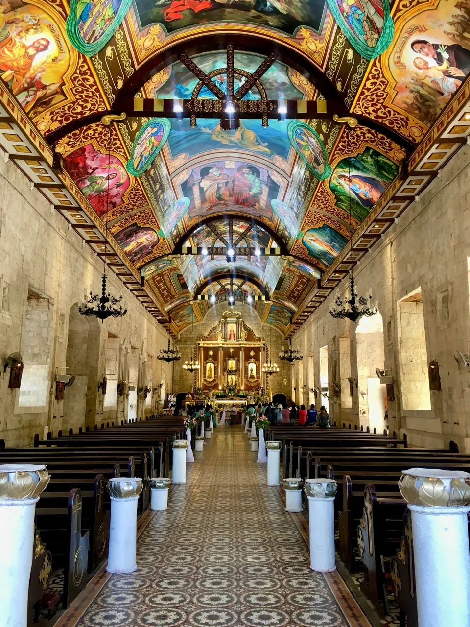 A view of the isle inside Saint Peter and Paul's parish. A wedding is seen to be taking place at the altar.