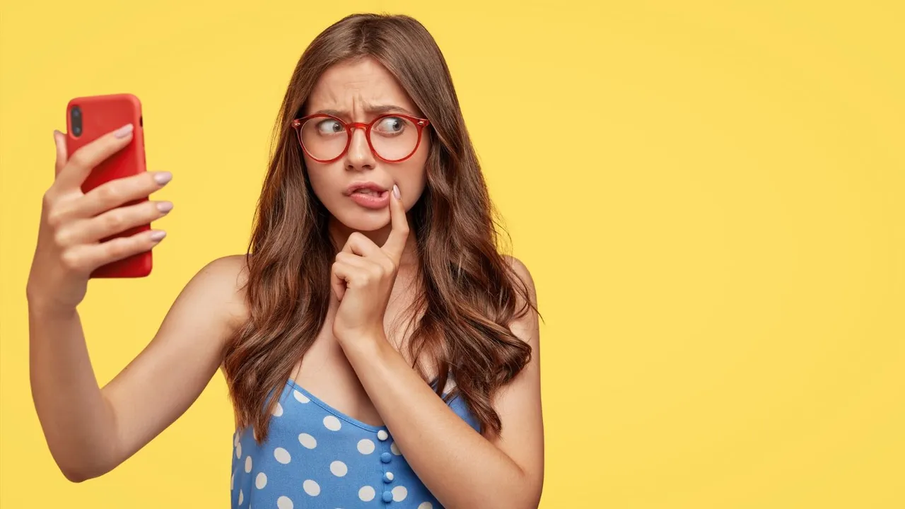embarrassed-young-european-lady-with-nervous-worried-expression-wears-spectacles-holds-modern-smart-phone-in-front.jpg