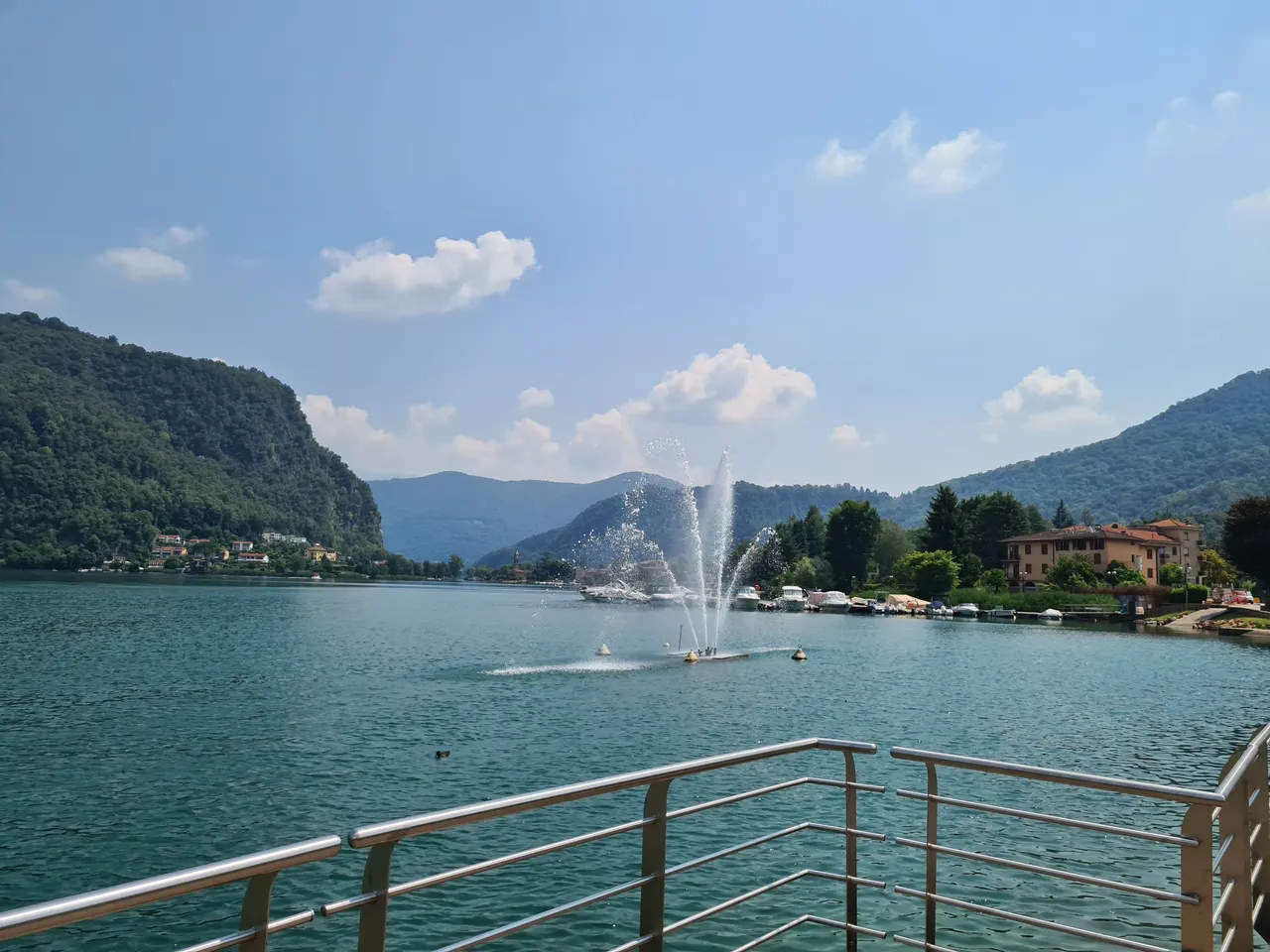 Vue sur le lac de Lugano, la fontaine de Ponte Tresa et les Alpes depuis Ponte Tresa en Italie
