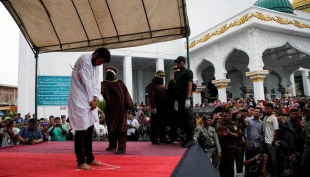 Seorang pria yang terbukti melakukan hubungan sesama jenis menerima hukuman cambuk di Banda Aceh, 23 Mei 2017. Sekitar 1.000 orang menyaksikan proses hukum cambuk tersebut. REUTERS.jpg