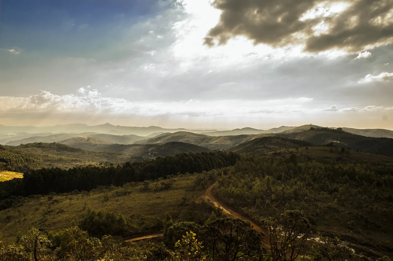 Sun shining down on green hills.