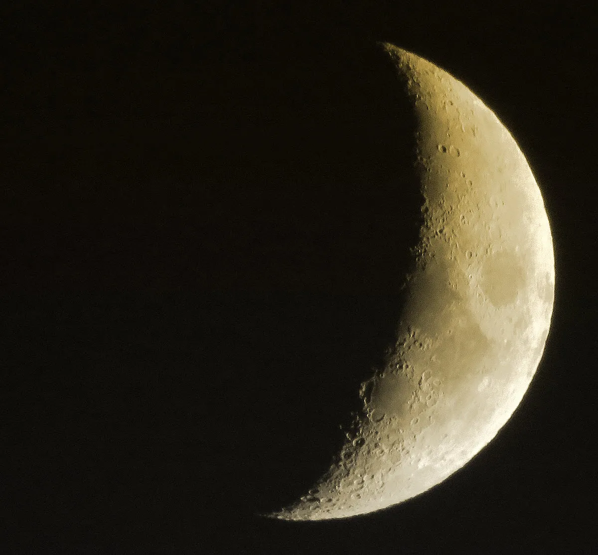 cresent orange tinted moon in dark sky.JPG