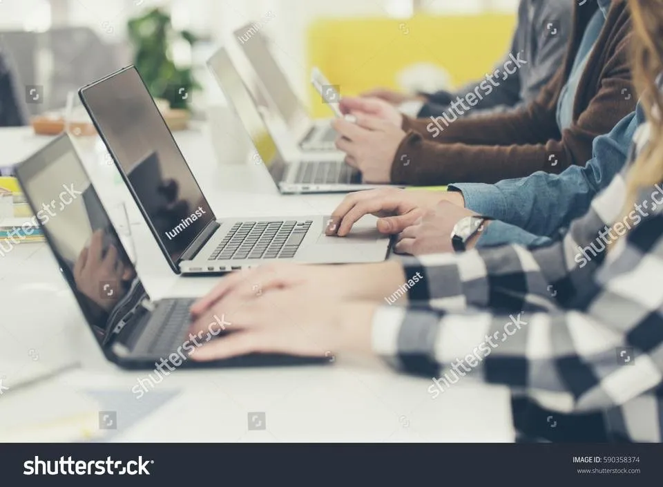 stock-photo-hands-of-group-of-unrecognisable-cropped-young-people-typing-on-laptop-590358374.jpg