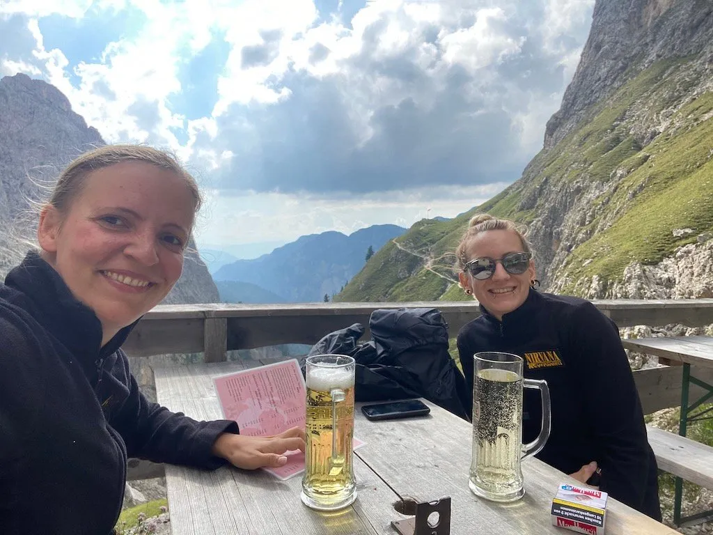 Sibylle und Rebecca sitzen mit Bier und Wein auf der Grasleitenhütte und genießen das tolle Flair der Hütte.