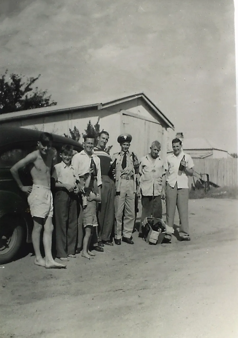 DAD IN NATIOS UNIFROM STANDING IN FRONT OF HOUSE IN VALLEY ST WITH GRANPA AND BOYS.png