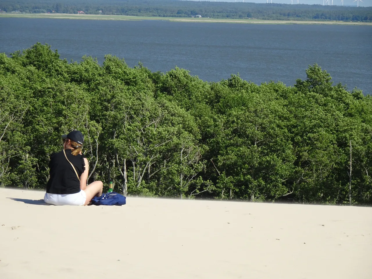 A girl is looking from the mountain made of sand