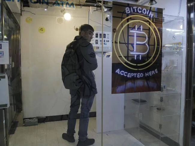 Ein Mann benutzt einen BitCoin-Automaten in HongKong