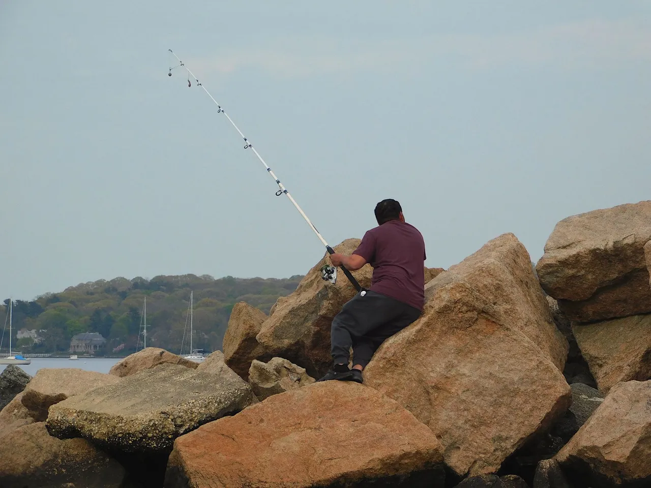 man fishing from the rocks amazing nature.png