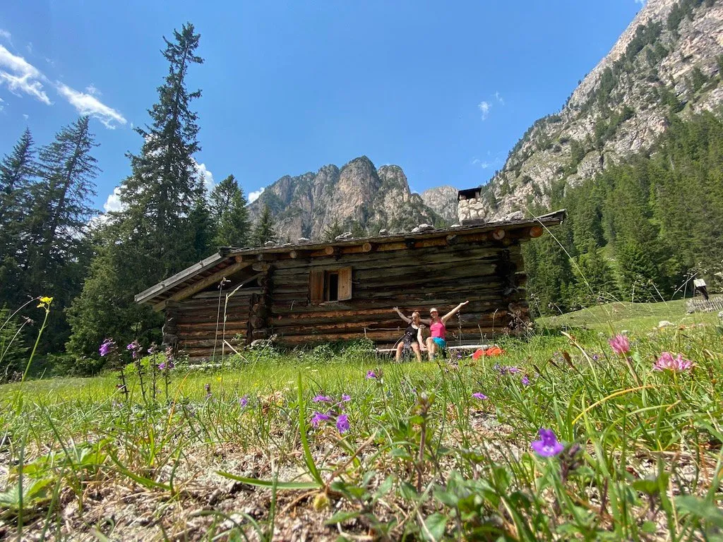 Sibylle und Rebecca sitzen vor einer alten Almhütte in den Dolomiten - 3 Tage Hüttentour in Südtirol