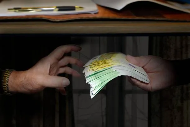 bribe-hands-exchanging-banknotes-picture-id928483194.jpg