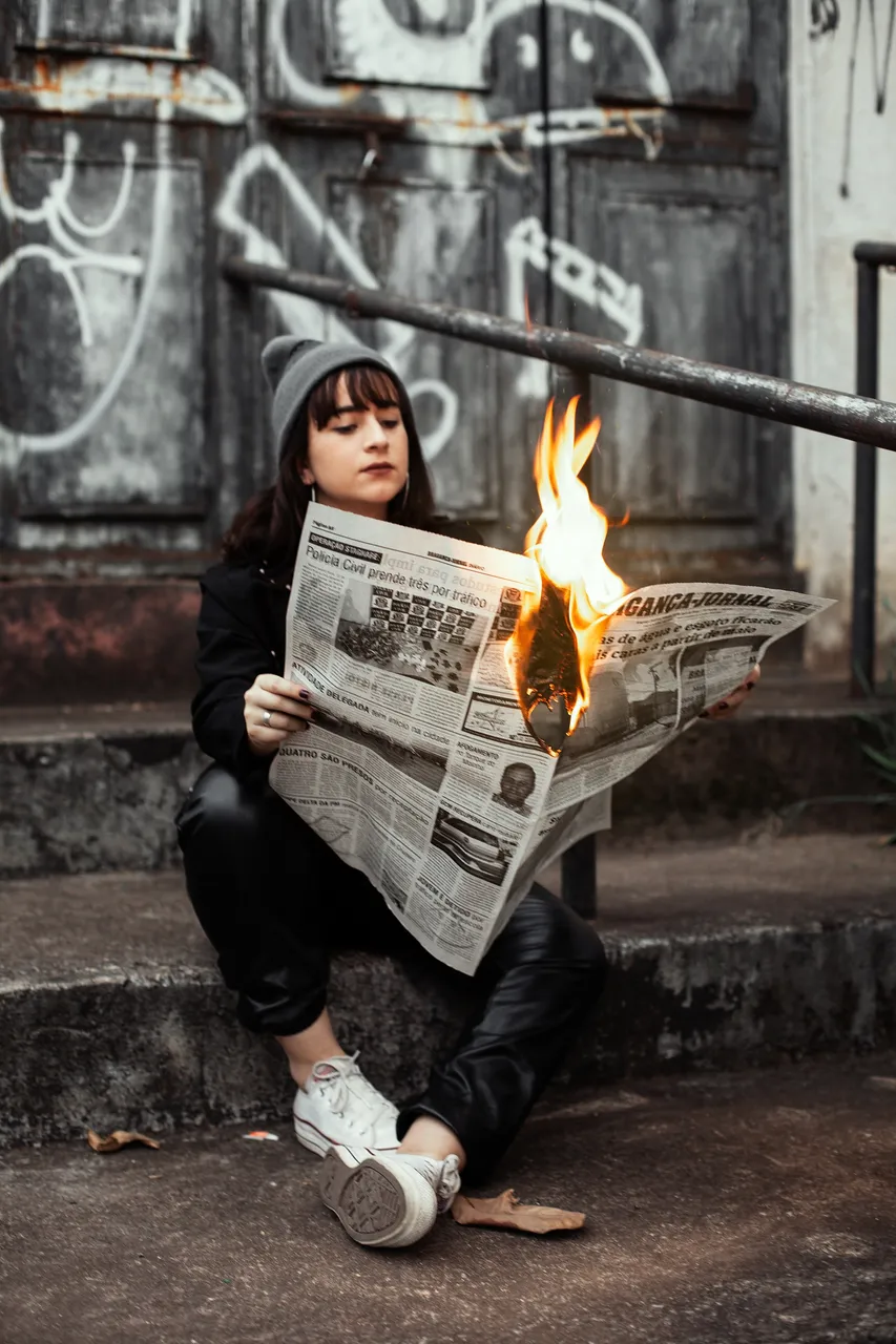 womanholdingnewspaperwhileburning3422053.jpg