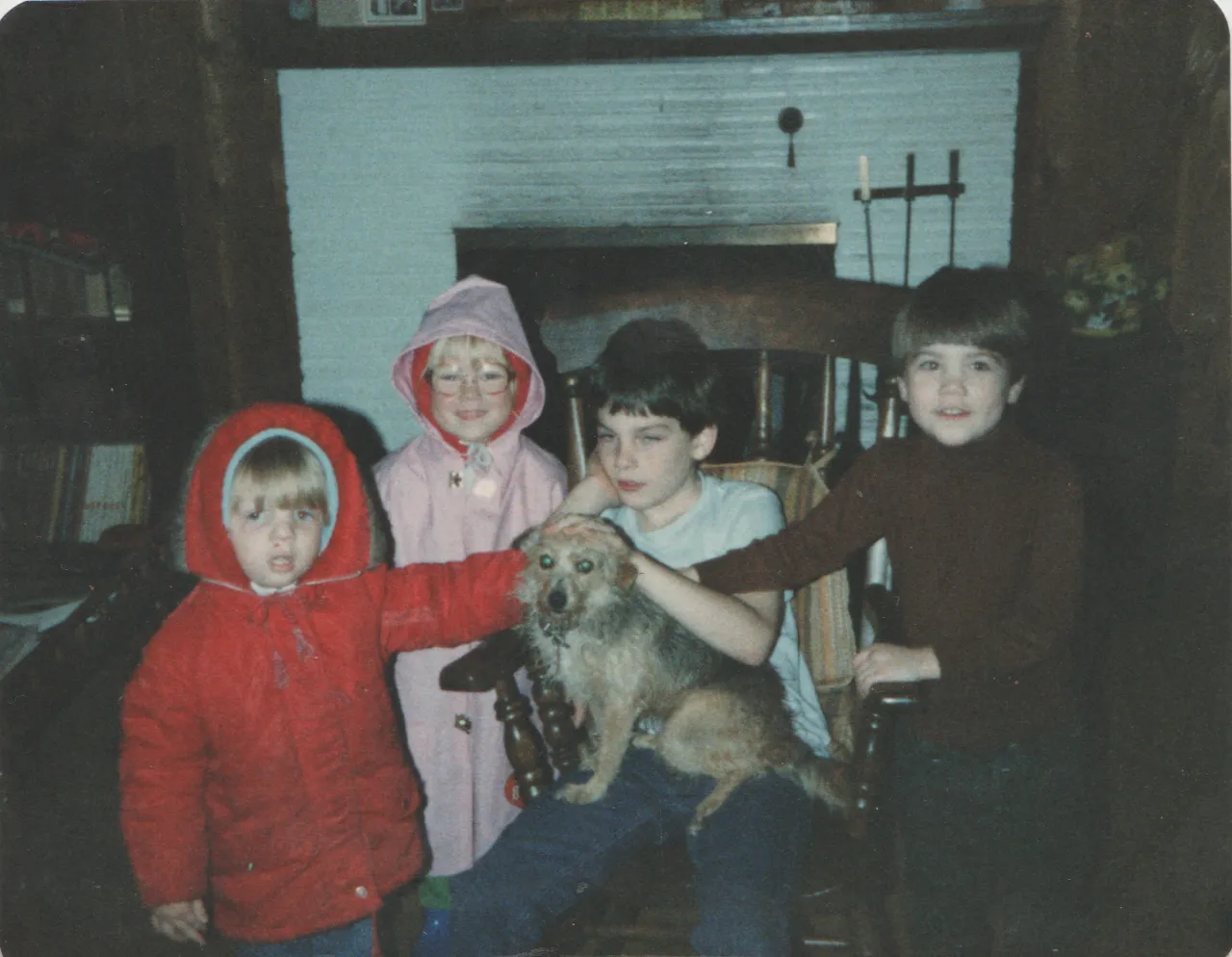 1985-08-16 - Friday - Rick in red rain jacket, Katie in pink jacket, Nathan petting a tan dog, Alan in brown long-sleeves, no date on this photo, at Karen's house.png