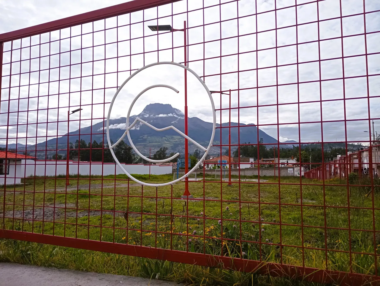 This is actually a low fence in comparison to others. The logo is of Cotacachi, but ironically the mountain in the picture is the Imbabura. The white part crossing the C is the shape of Mountain Cotacachi.