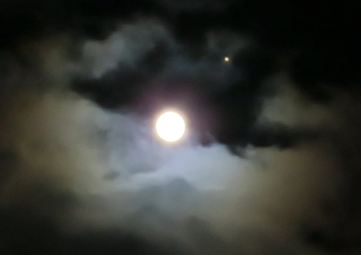 bright full moon and orange star above colored clouds.JPG