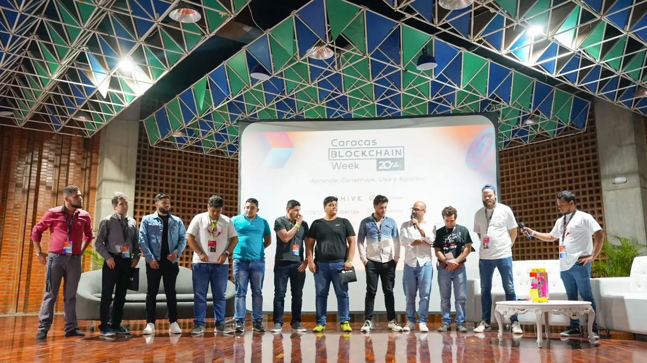 @enrique89 y @starketz en el escenario entregando el premio a los ganadores del hackathon en el track de Hive y SPK Network - @enrique89 and @starketz on stage awarding the prize to the winners of the hackathon on the Hive and SPK Network track.