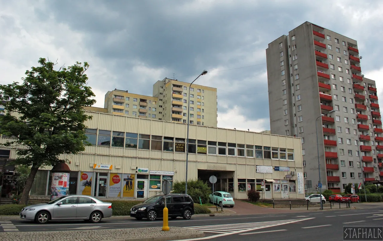 Typowy "dom handlowy" z czasów PRL. W tle blokowisko. | A typical "department store" from the times of the Polish People's Republic. A typical housing estate from the PRL time in the background.