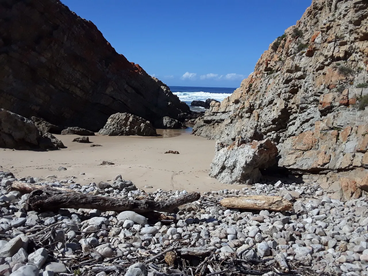 Rockier terrain beyond the Arch Rock as the trail continues along the coastline