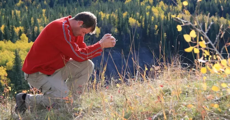 15249-man-bowing-down-in-prayer-outdoors-lead-with.webp