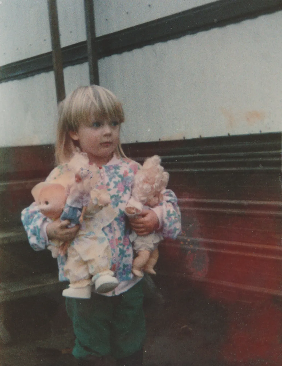 1992-12 - Crystal holding dolls, Christmas, December, could be 92 but it says 93, next to our house, near porch.png