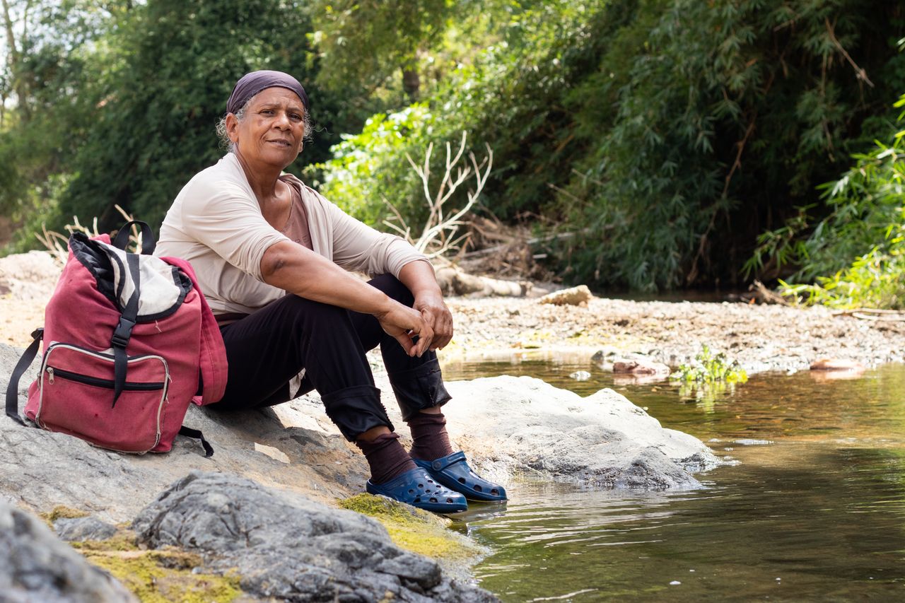 Mujer descansando en el recodo del río.