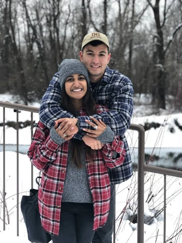 Image may contain: 2 people, people smiling, people standing, tree, hat and outdoor