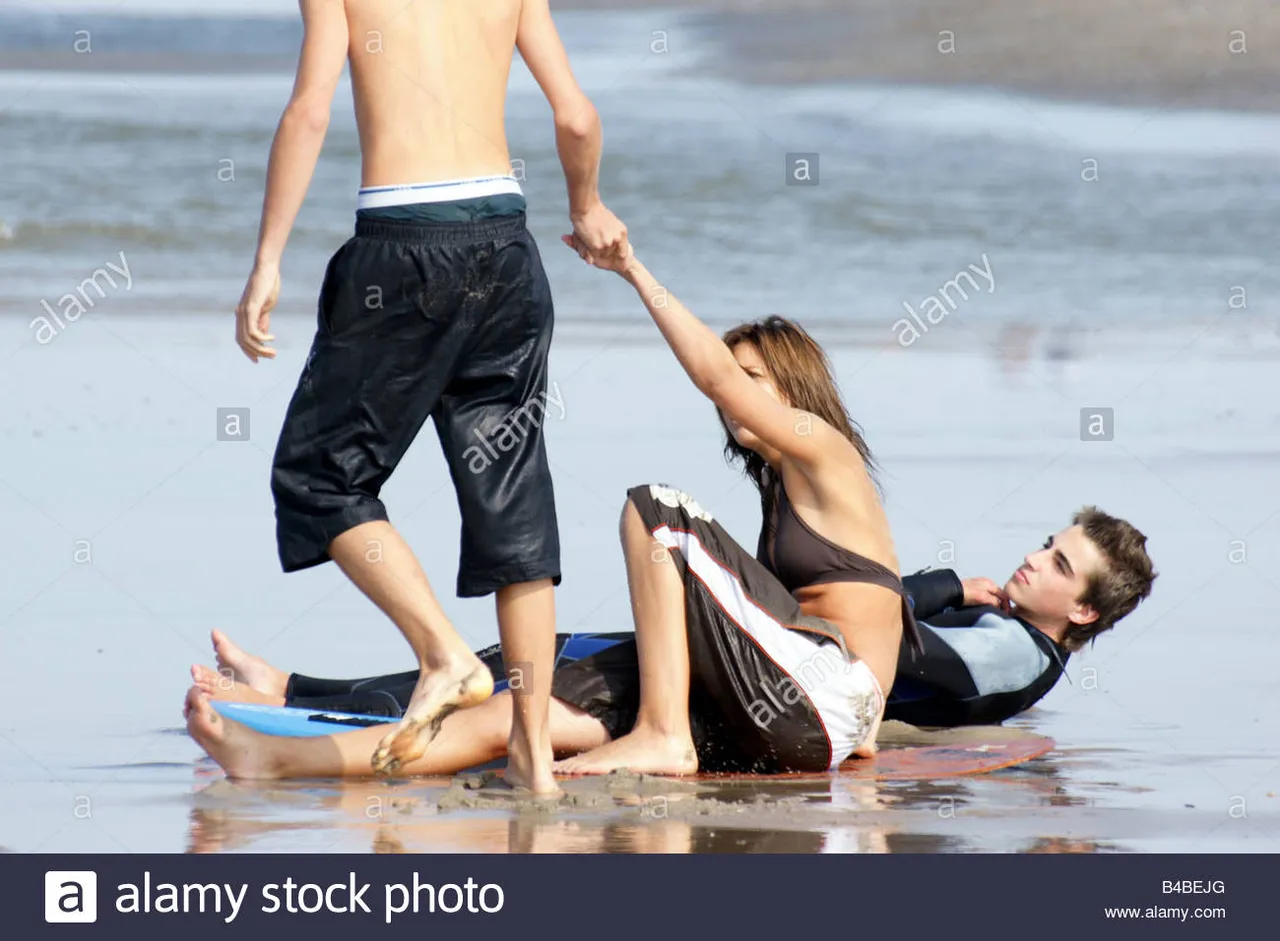 young-man-woman-teenage-girl-boy-bare-feet-beach-shallow-water-sea-B4BEJG.jpg