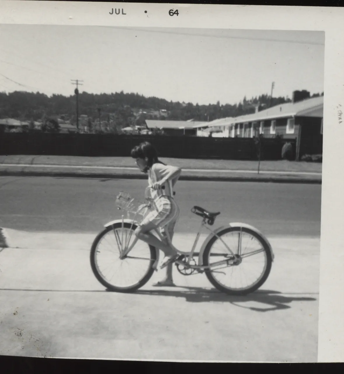 1964-07 Girl Bike Ponytail.png