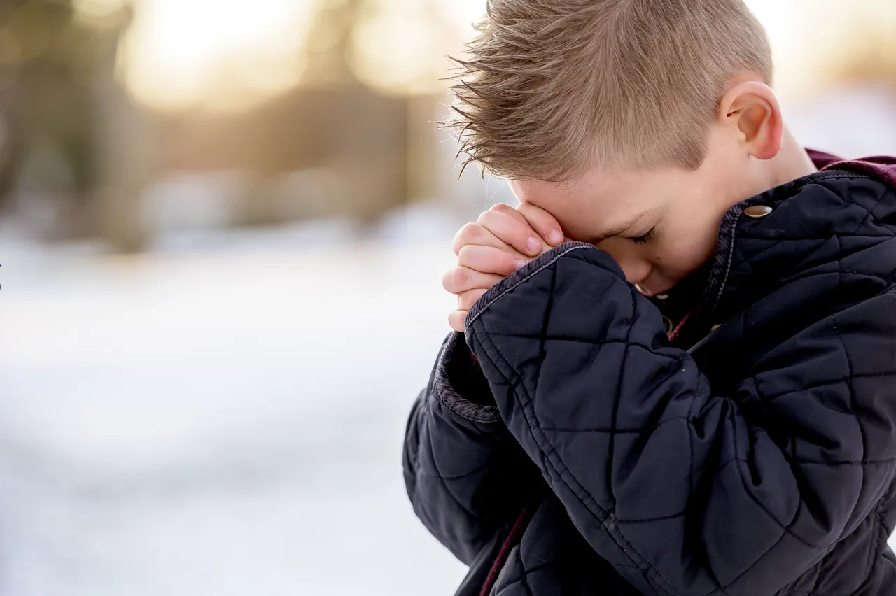 boy-standing-with-closed-eyes-praying.jpg