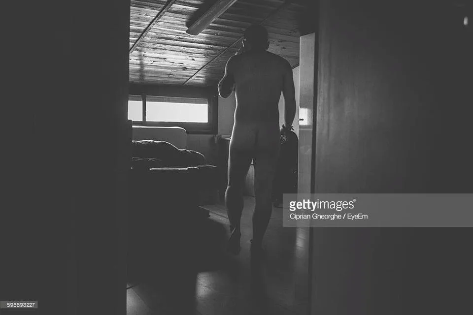 rear-view-of-naked-man-talking-on-phone-while-walking-at-home-picture-id595893227.jpeg