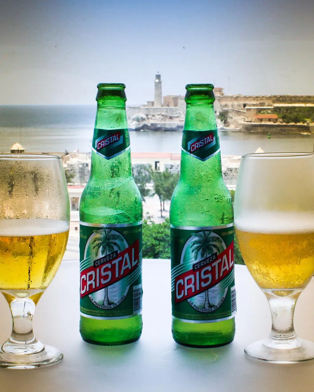 Vista desde la Terraza del Hotel Packard en la Habana, en frente el Morro enmarcado entre dos cervezas Cristal.