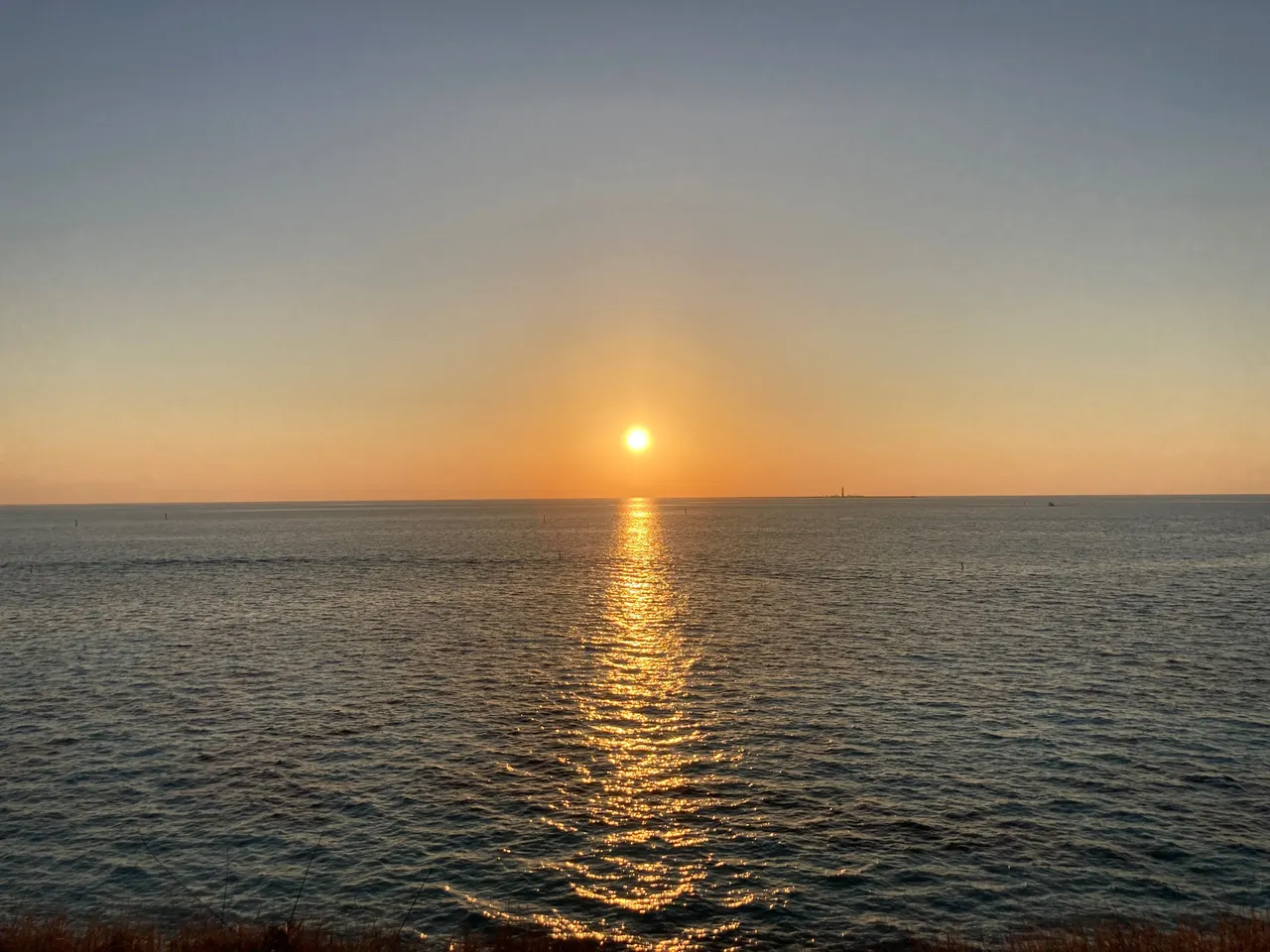 Sunset with lighthouse on horizon