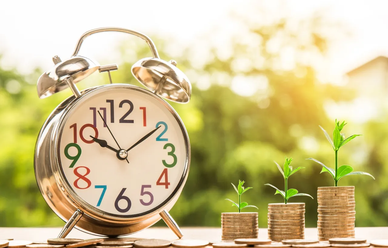 a clock and 3 piles of coins with plants sprouting from them