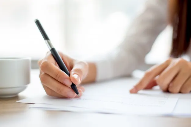 hand-of-businesswoman-writing-on-paper-in-office_1262-2119.jpg