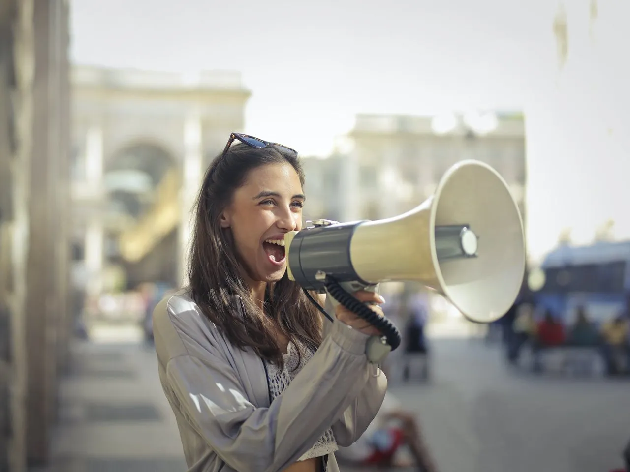 cheerful young woman screaming into megaphone - image for New Year 2021