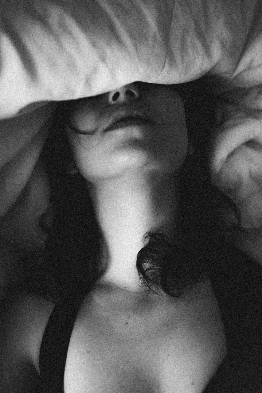 monochrome-photo-of-female-face-covered-by-pillow-3683696.jpg