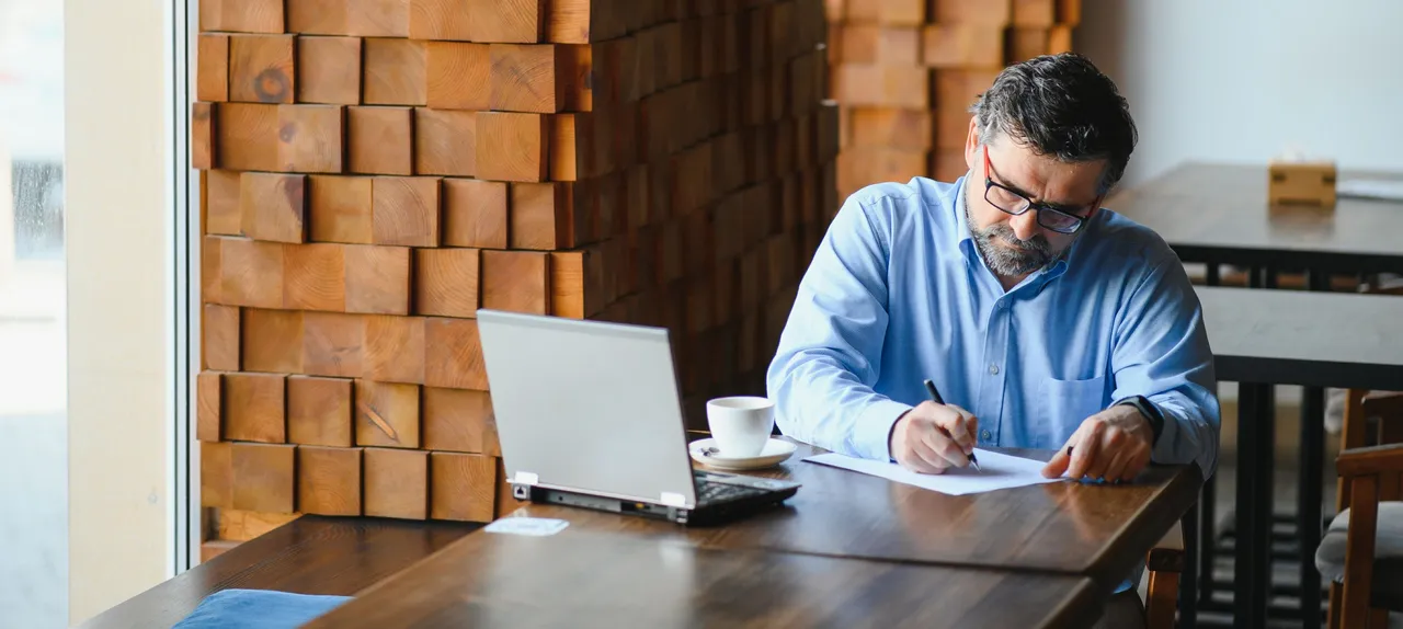 male-freelancer-is-working-cafe-new-business-project-sits-large-window-table-looks-laptop-screen-with-cup-coffee copy.jpg