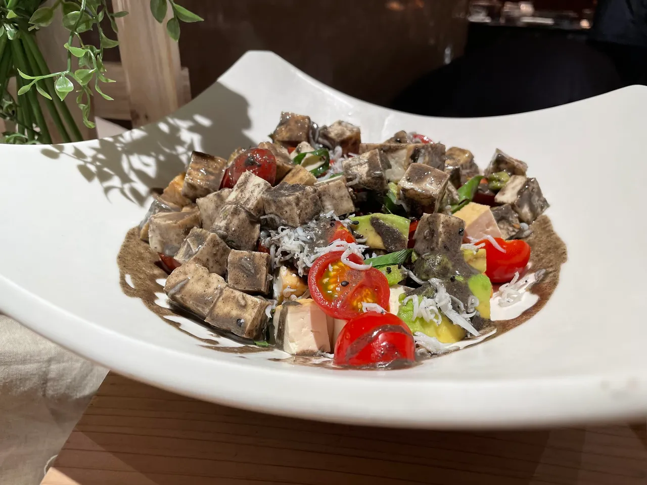 Fried tofu salad with avocado and tomato in black sesame