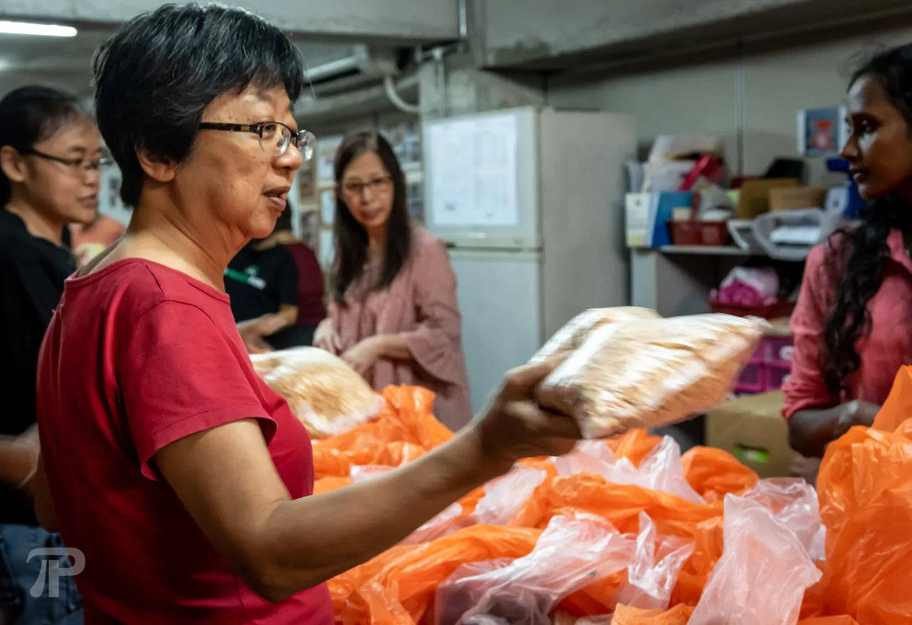 The volunteers formed a chain, passing the groceries while making sure that every bag receives the same items