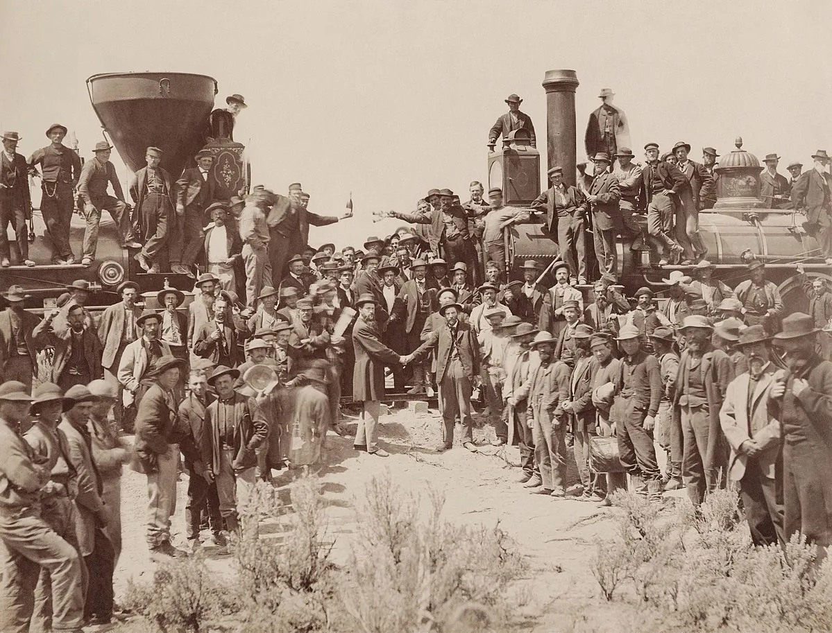 1200px-East_and_West_Shaking_hands_at_the_laying_of_last_rail_Union_Pacific_Railroad_-_Restoration.jpg