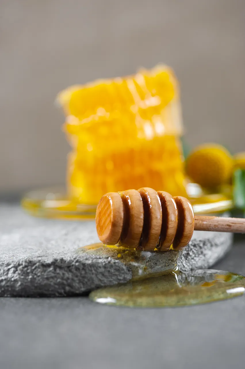 wooden-spoon-for-honey-and-honey-on-a-gray-cement-AL63SCX.jpg