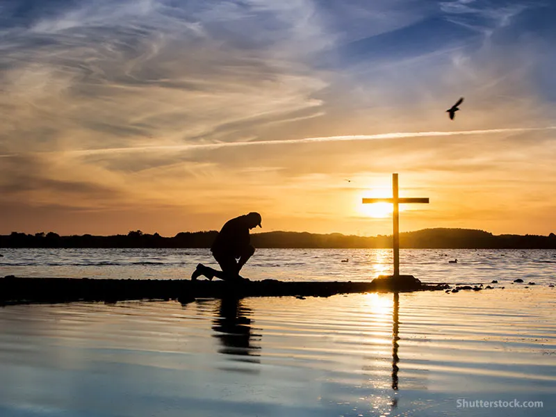 man-kneeling-prayer-cross-water.jpg