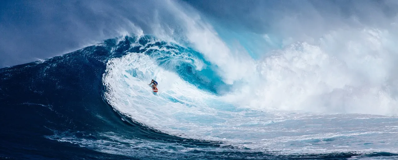 A surfing riding a very large wave.