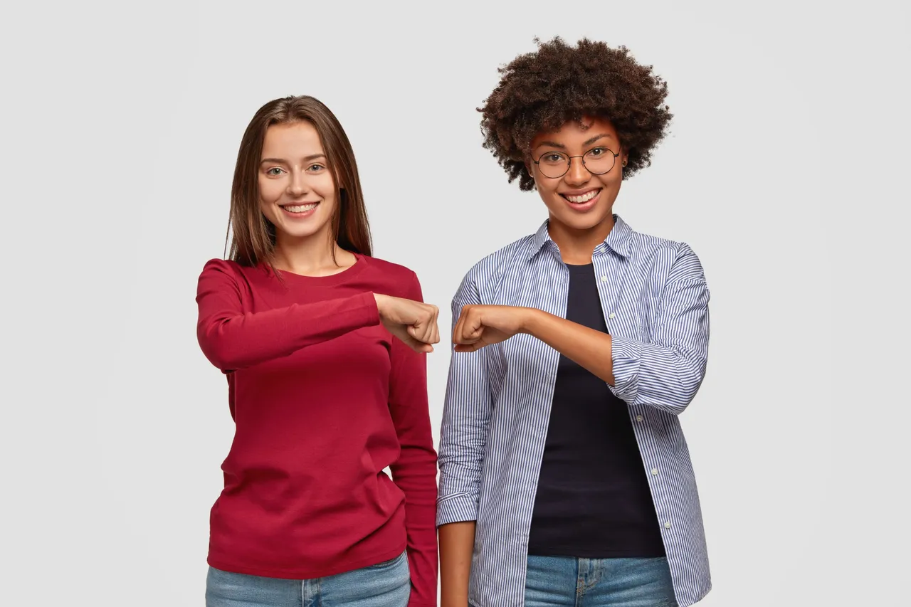 multiethnic-young-women-give-fist-bump-to-each-other.jpg